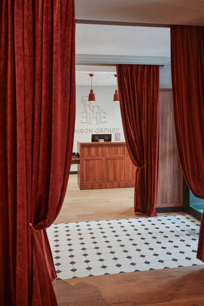 Hall d'entrée d'un hôtel parisien avec ses grands rideaux rouge.
