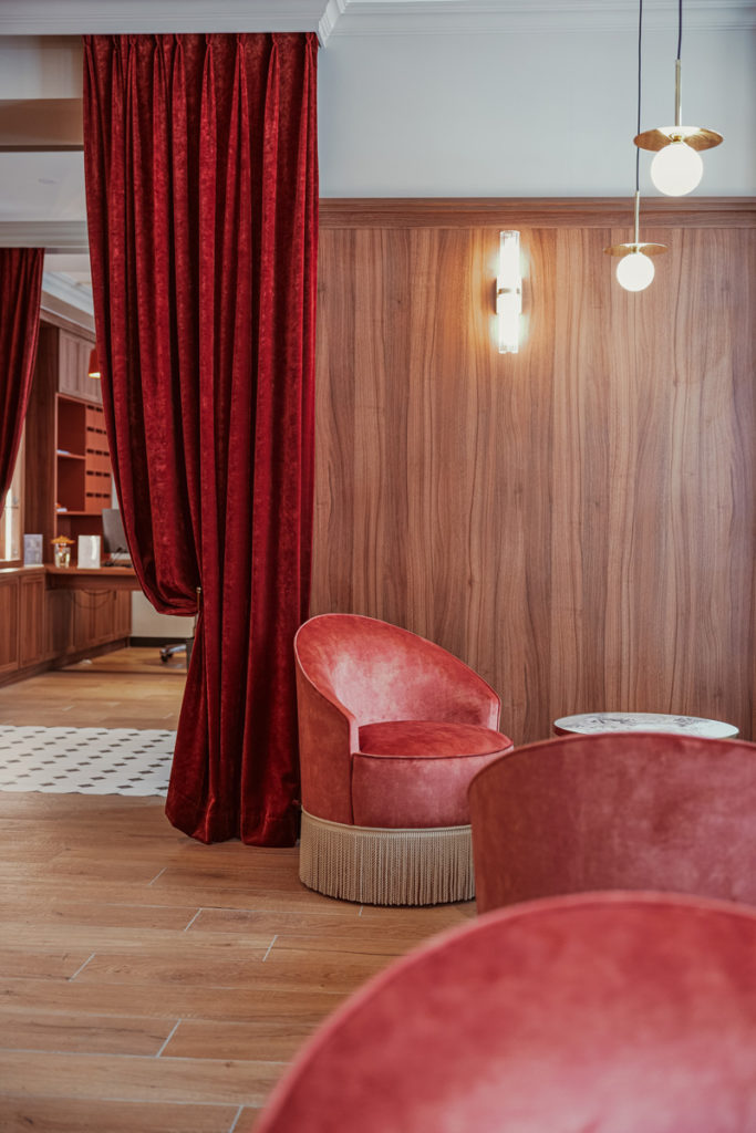 Assise dans l'accueil d'un hôtel parisien avec ses fauteuils contemporains.